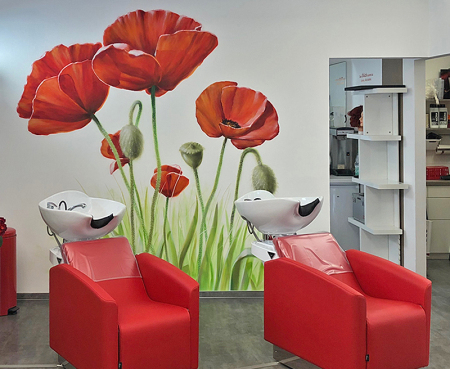 Gesprühte Mohnblüten mit Grashalmen auf einer weißen Innenwand von einem Friseursalon in Berlin.