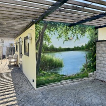 Eine Hauswandfassade wurde zum Ruhepol unter einer Pergola auf der Terasse.